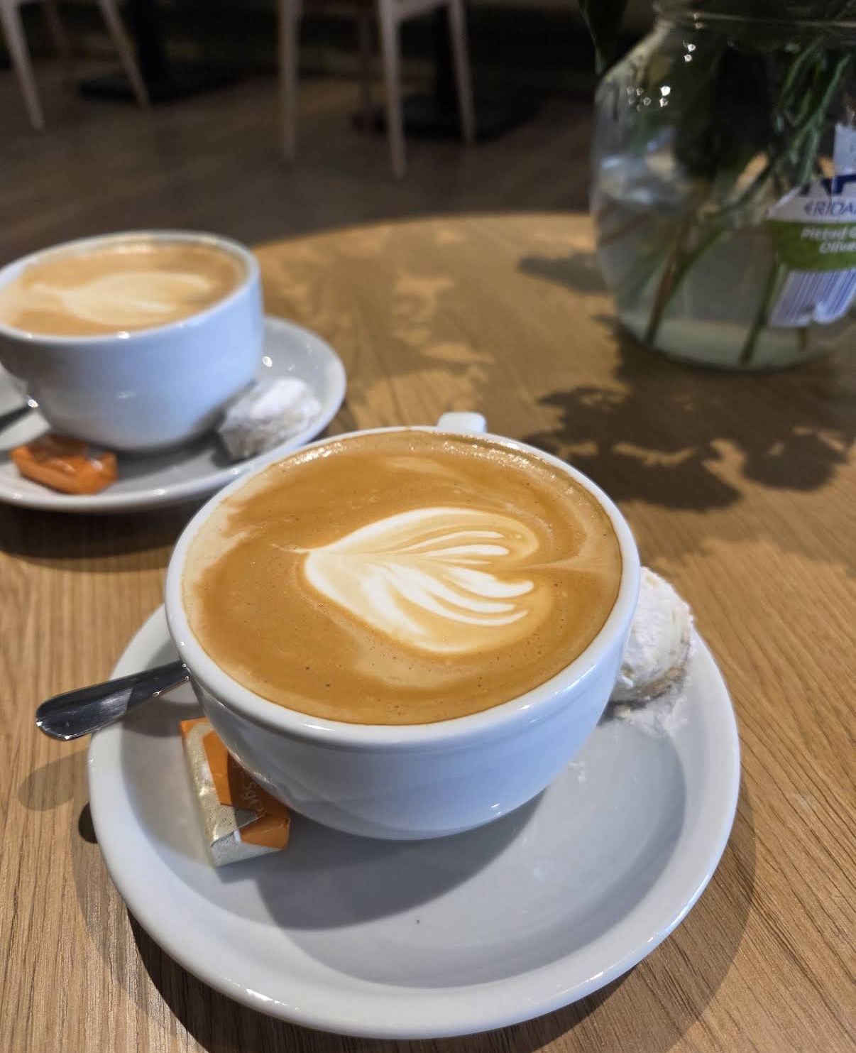 Flat white with latte art, kourabie on the saucer
