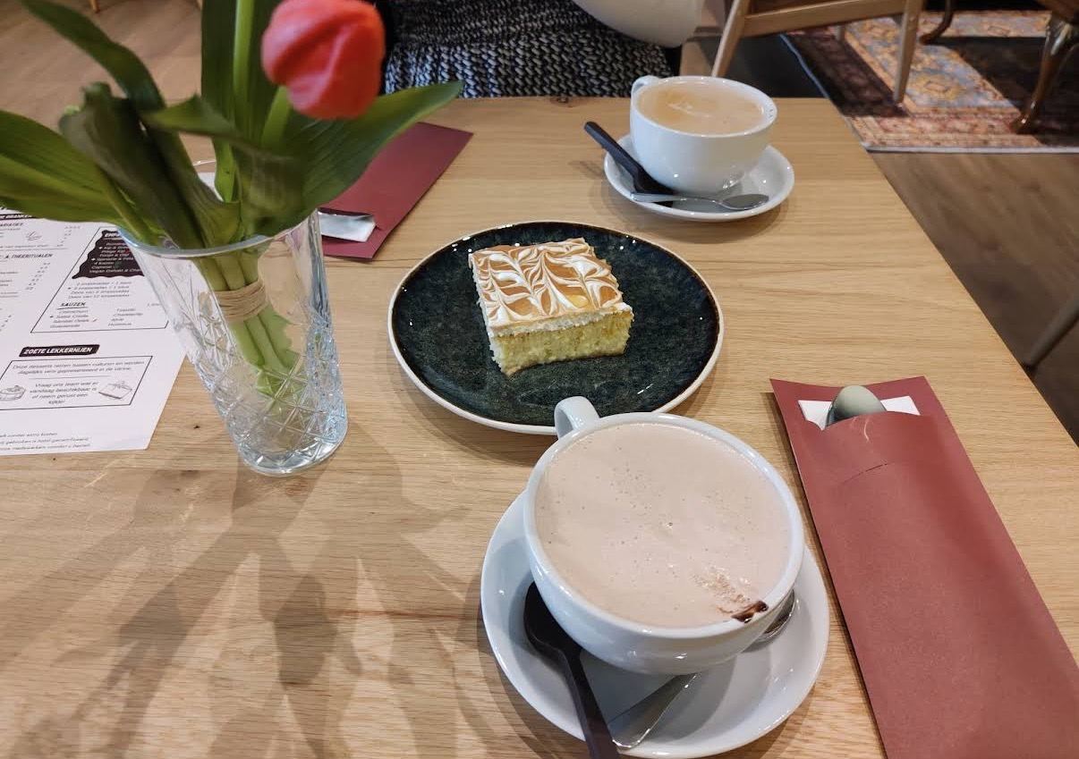 Cappuccino, hot chocolate and tres leches on an oak table